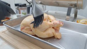Hähnchen mit Butter und Öl bestreichen